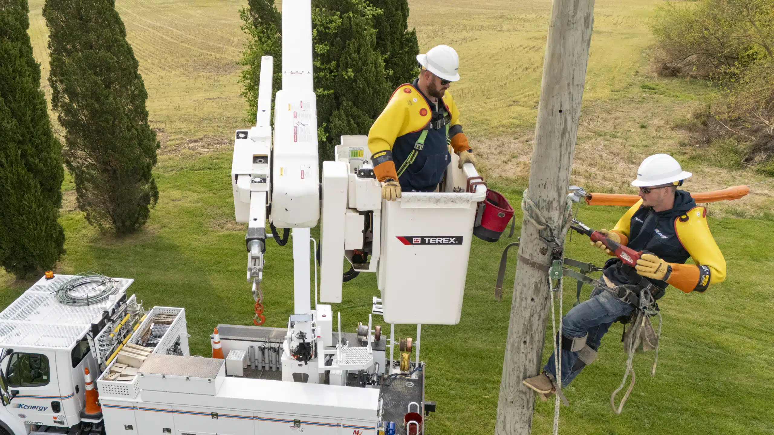 Kenergy linemen on a utility pole work on an electric line.